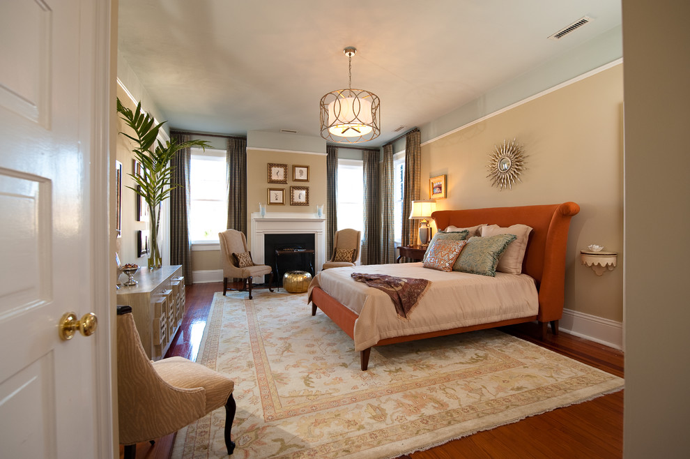 Photo of a large eclectic master bedroom in Charleston with beige walls, dark hardwood flooring, a standard fireplace, a tiled fireplace surround and brown floors.
