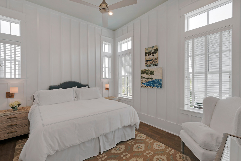 Ejemplo de habitación de invitados marinera de tamaño medio sin chimenea con paredes blancas, suelo de madera en tonos medios y suelo marrón