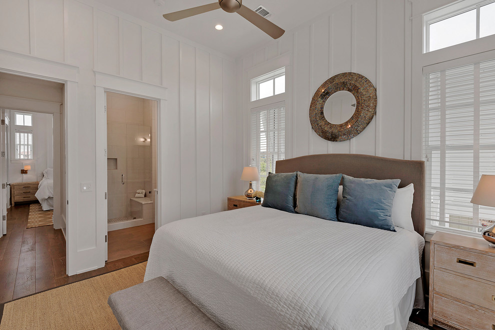 Ejemplo de habitación de invitados costera de tamaño medio sin chimenea con paredes blancas, suelo de madera en tonos medios y suelo marrón