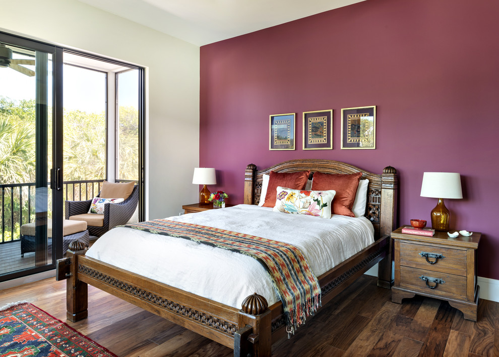 World-inspired master bedroom in Miami with purple walls, dark hardwood flooring and no fireplace.