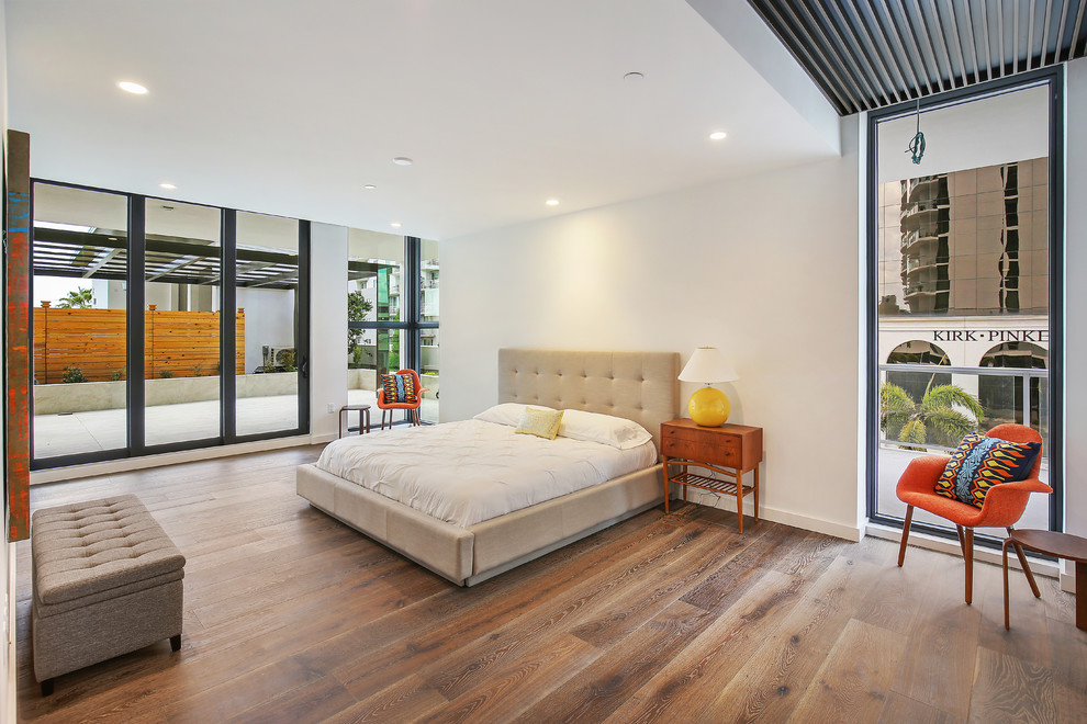 Ejemplo de dormitorio principal actual grande sin chimenea con paredes beige, suelo de madera en tonos medios y suelo marrón