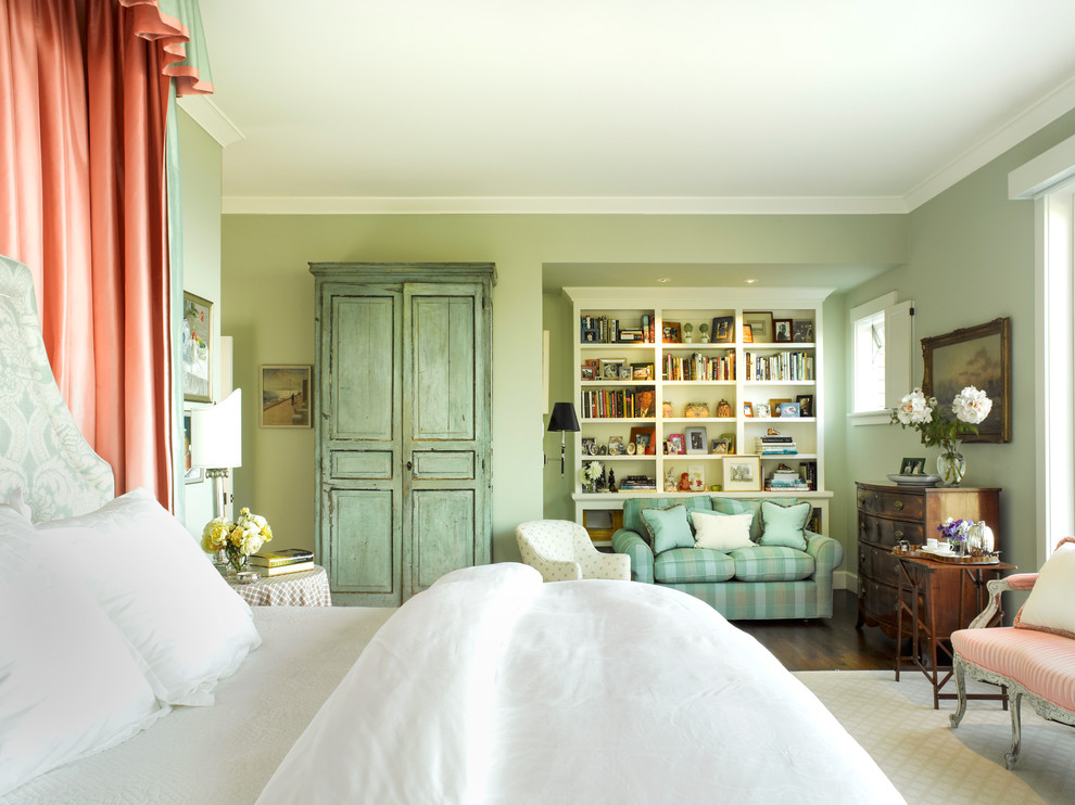 Modelo de dormitorio principal tradicional de tamaño medio con paredes verdes y suelo de madera oscura