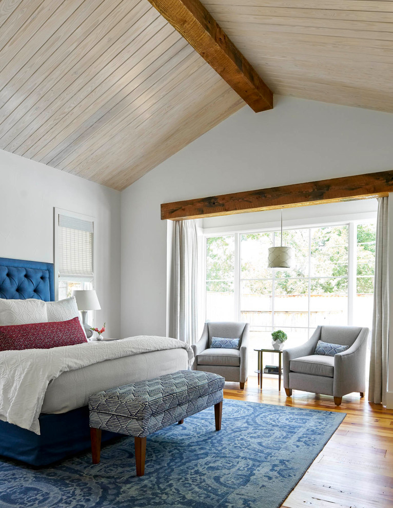 Inspiration for a farmhouse master medium tone wood floor bedroom remodel in Dallas with white walls