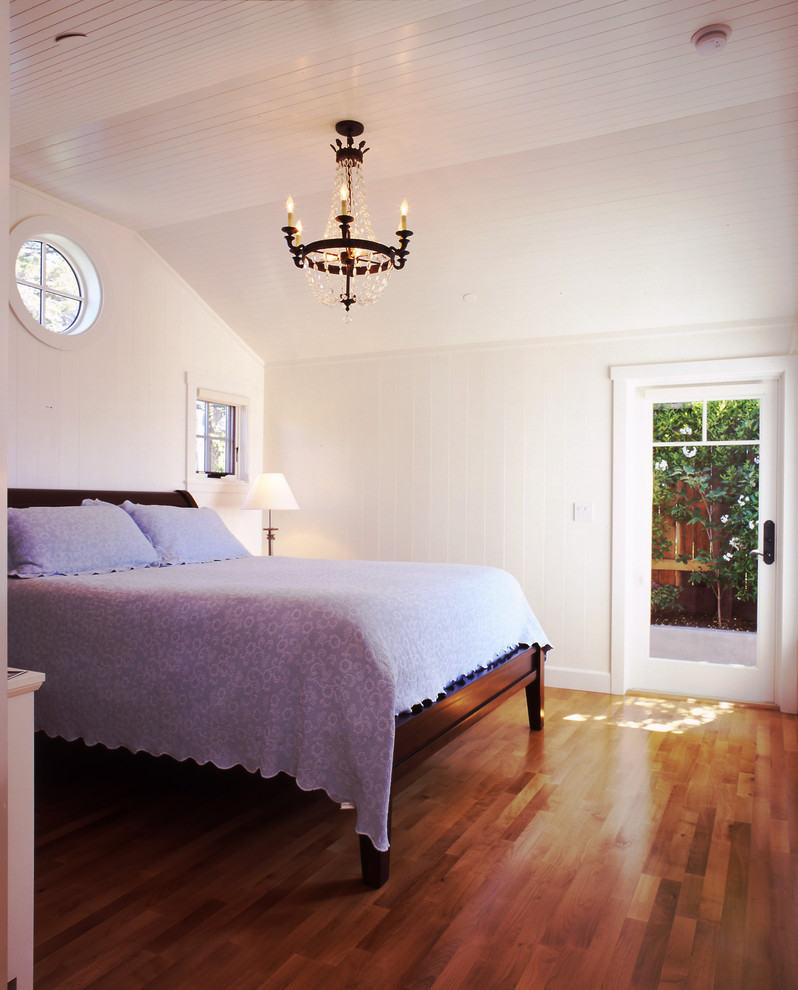 Ejemplo de habitación de invitados costera de tamaño medio sin chimenea con paredes blancas y suelo de madera en tonos medios