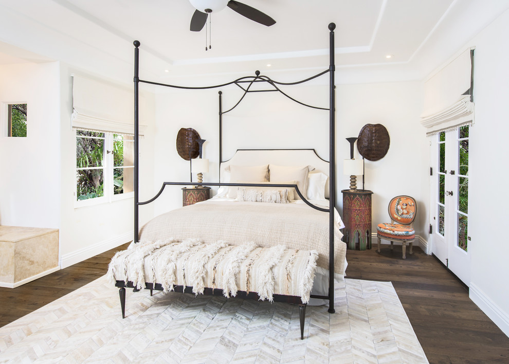 ロサンゼルスにある広い地中海スタイルのおしゃれな客用寝室 (濃色無垢フローリング、標準型暖炉、石材の暖炉まわり、ベージュの壁)