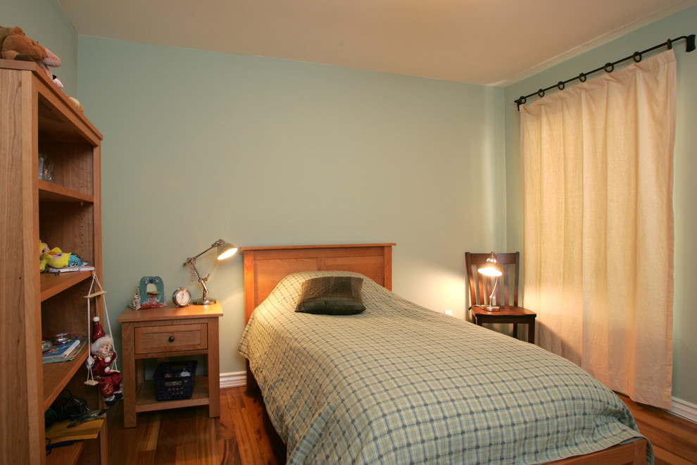 Ejemplo de habitación de invitados actual pequeña sin chimenea con paredes verdes, suelo de madera clara y suelo marrón