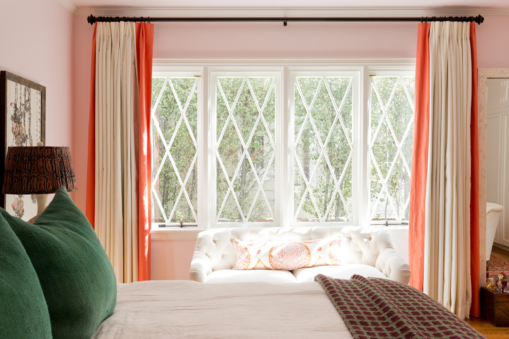 Exemple d'une grande chambre parentale éclectique avec un mur rose, un sol en bois brun, aucune cheminée et un sol marron.
