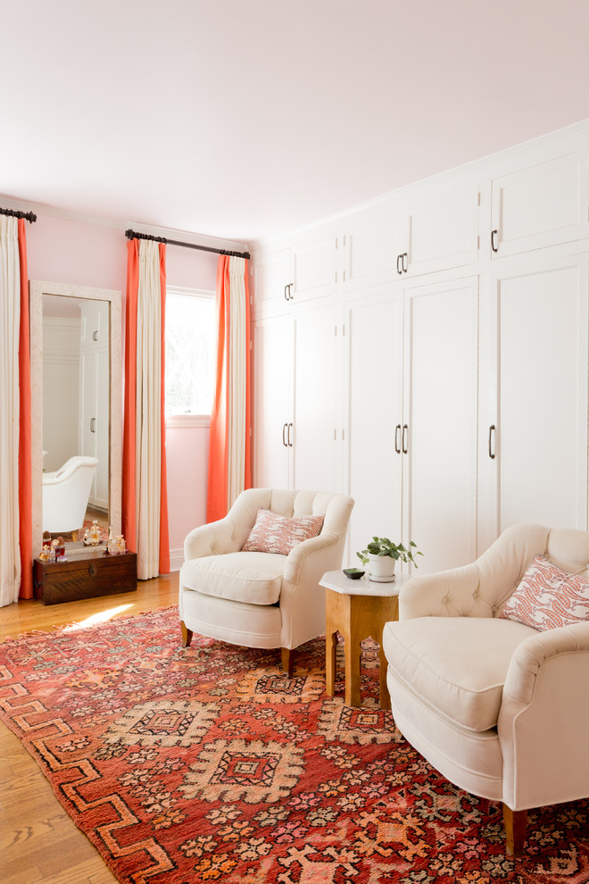 Foto de dormitorio principal ecléctico grande sin chimenea con suelo de madera en tonos medios, paredes rosas y suelo marrón