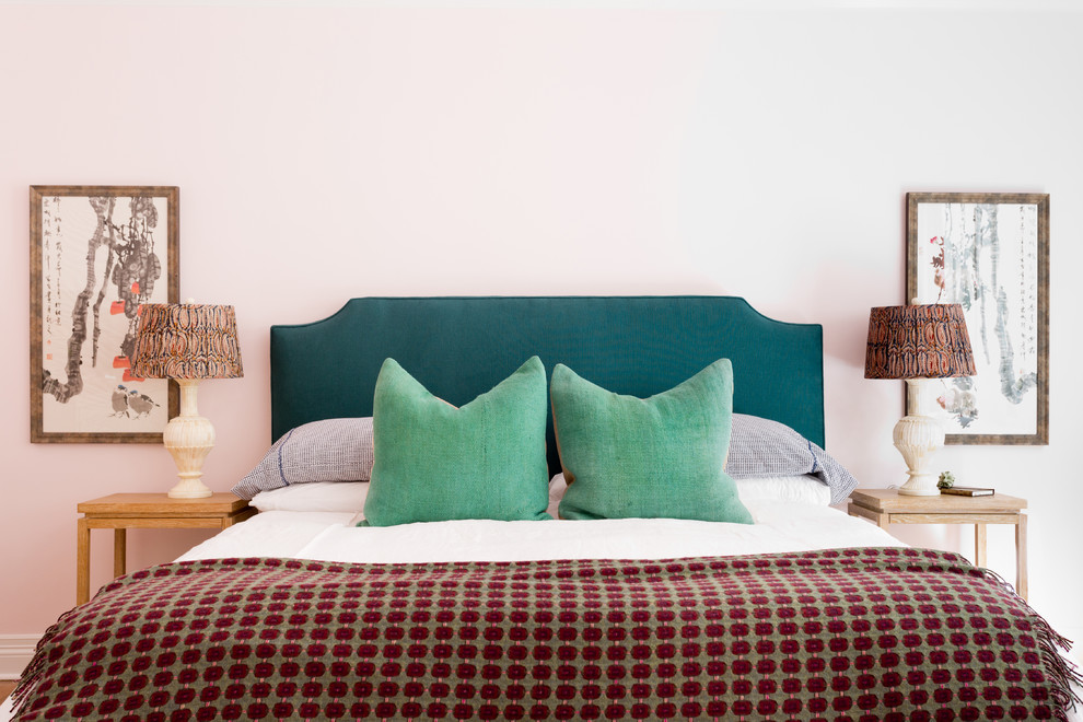 Ejemplo de dormitorio principal ecléctico grande sin chimenea con paredes rosas, suelo de madera en tonos medios y suelo marrón