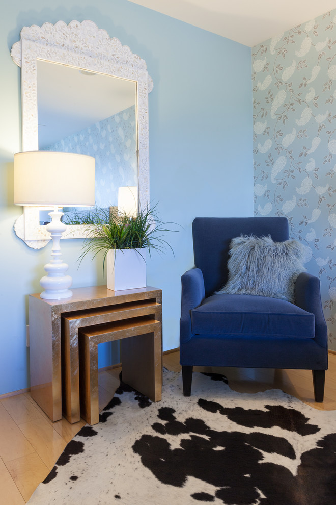 Diseño de dormitorio principal clásico renovado grande sin chimenea con paredes azules y suelo de madera clara