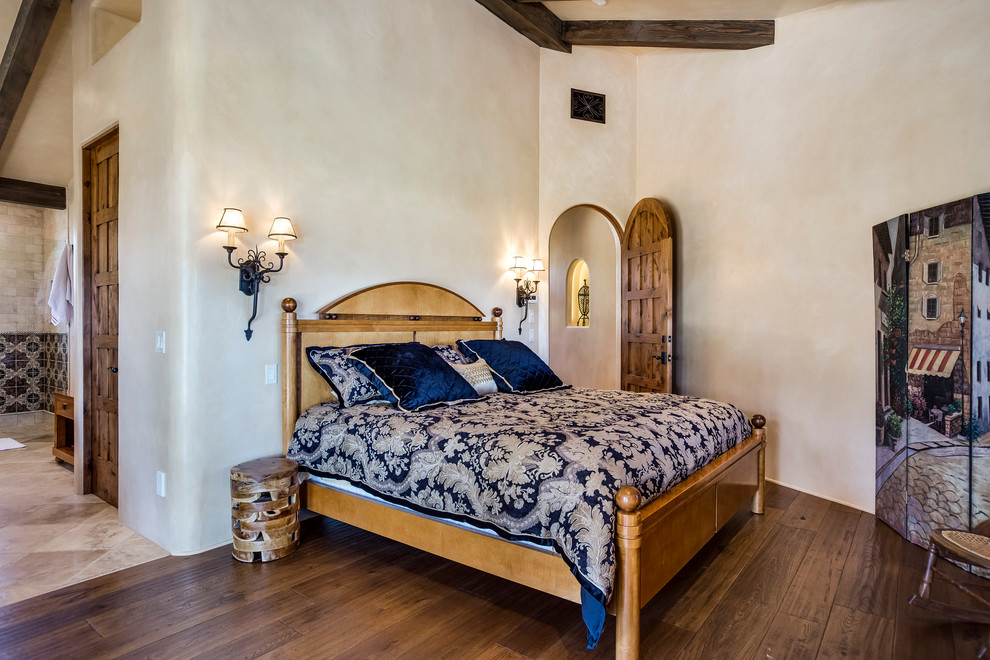 Diseño de habitación de invitados de estilo americano grande sin chimenea con paredes beige y suelo de madera oscura