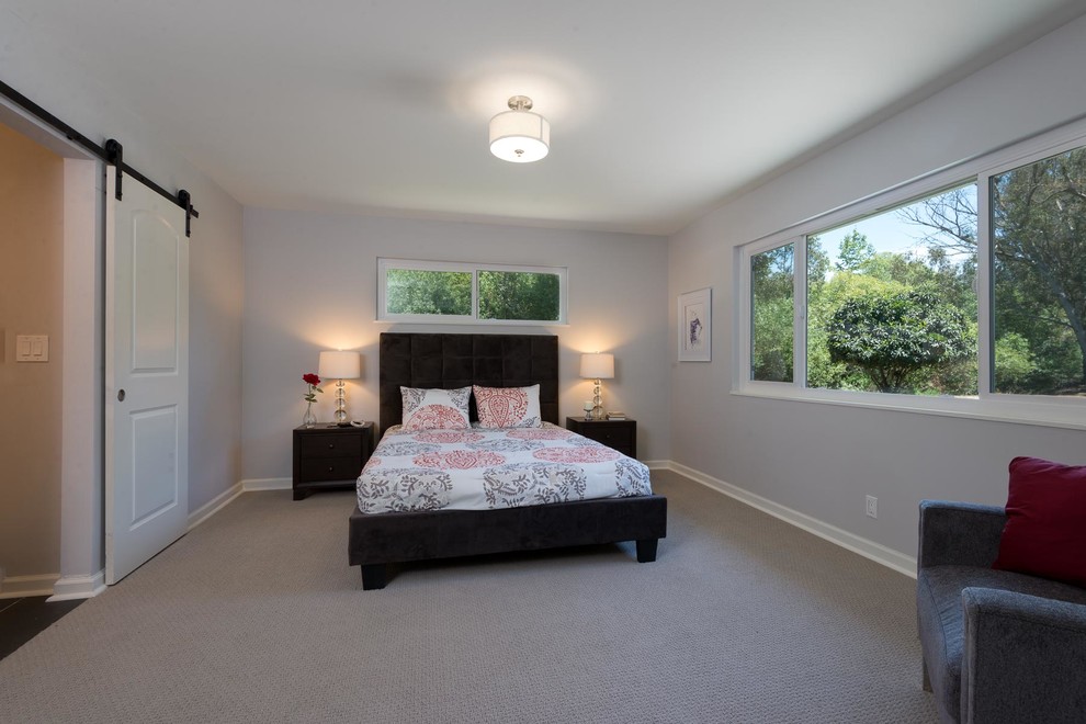 This is an example of a medium sized contemporary master bedroom in Sacramento with grey walls and carpet.