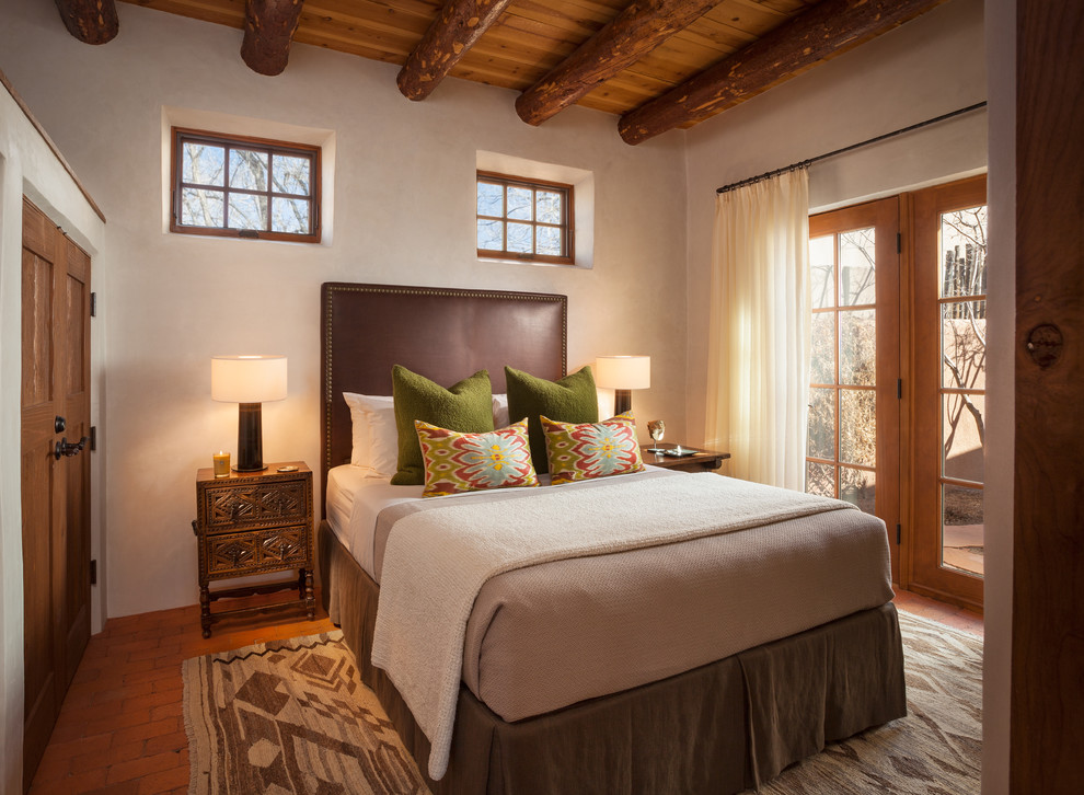 Foto de habitación de invitados de estilo americano sin chimenea con paredes beige y suelo de ladrillo