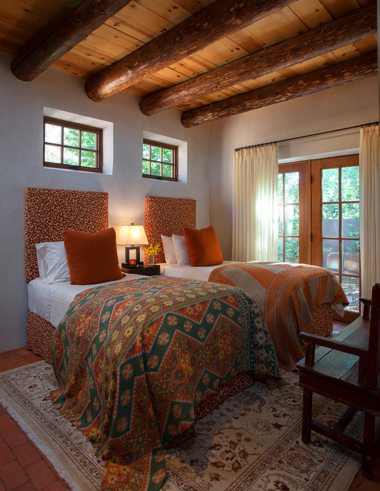 Foto de habitación de invitados de estilo americano de tamaño medio sin chimenea con paredes beige y suelo de ladrillo