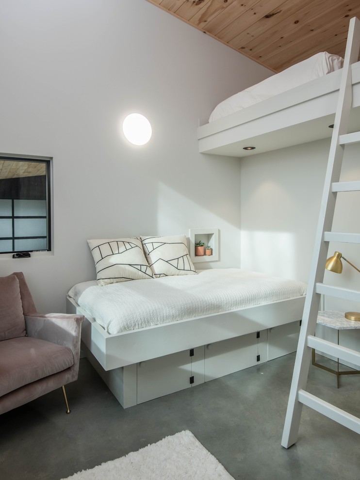 Foto på ett minimalistiskt gästrum, med vita väggar, betonggolv och grått golv
