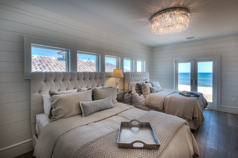 マイアミにあるビーチスタイルのおしゃれな客用寝室 (白い壁、淡色無垢フローリング、照明) のインテリア