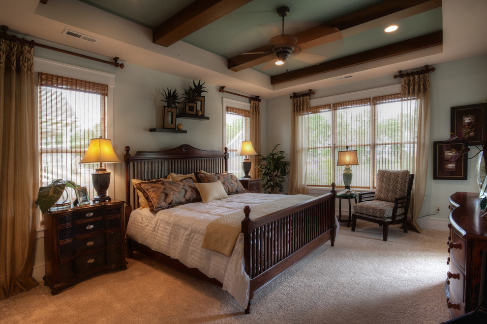 This is an example of a medium sized world-inspired master bedroom in Other with blue walls, carpet and beige floors.