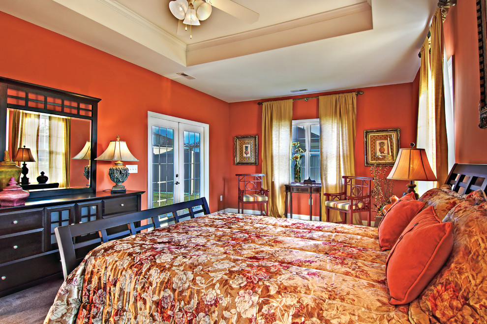 Imagen de dormitorio principal clásico de tamaño medio sin chimenea con parades naranjas y moqueta