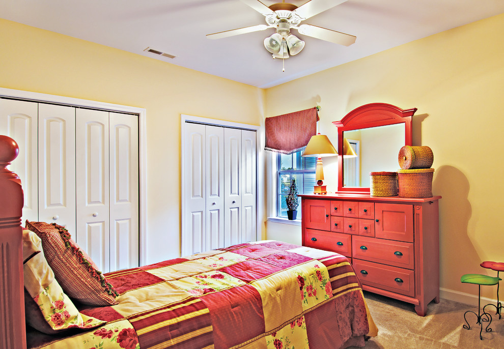 Modelo de habitación de invitados tradicional de tamaño medio sin chimenea con paredes amarillas y moqueta
