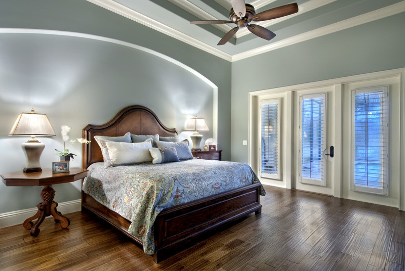 На фото: большая хозяйская спальня в средиземноморском стиле с зелеными стенами и паркетным полом среднего тона без камина с