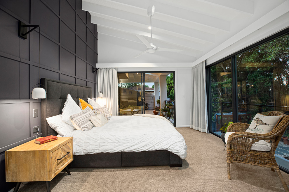 На фото: большая хозяйская спальня в современном стиле с ковровым покрытием, балками на потолке и панелями на стенах с