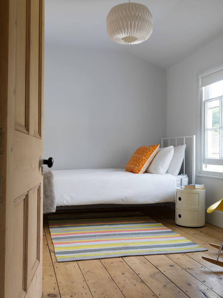 他の地域にあるカントリー風のおしゃれな客用寝室 (グレーの壁、無垢フローリング、茶色い床、グレーとブラウン)