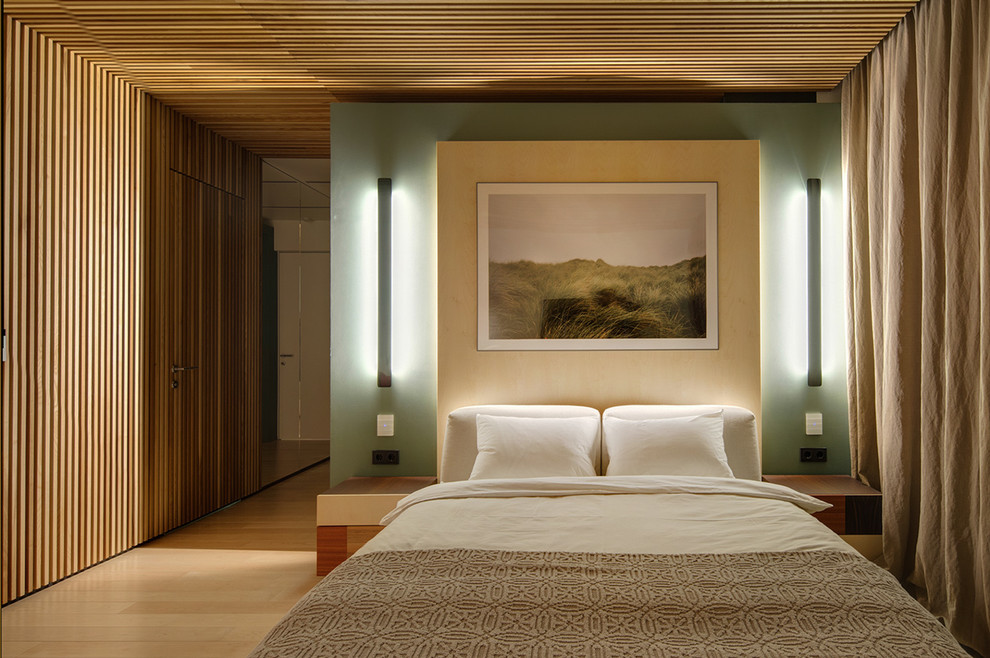 Inredning av ett modernt sovrum, med gröna väggar och ljust trägolv