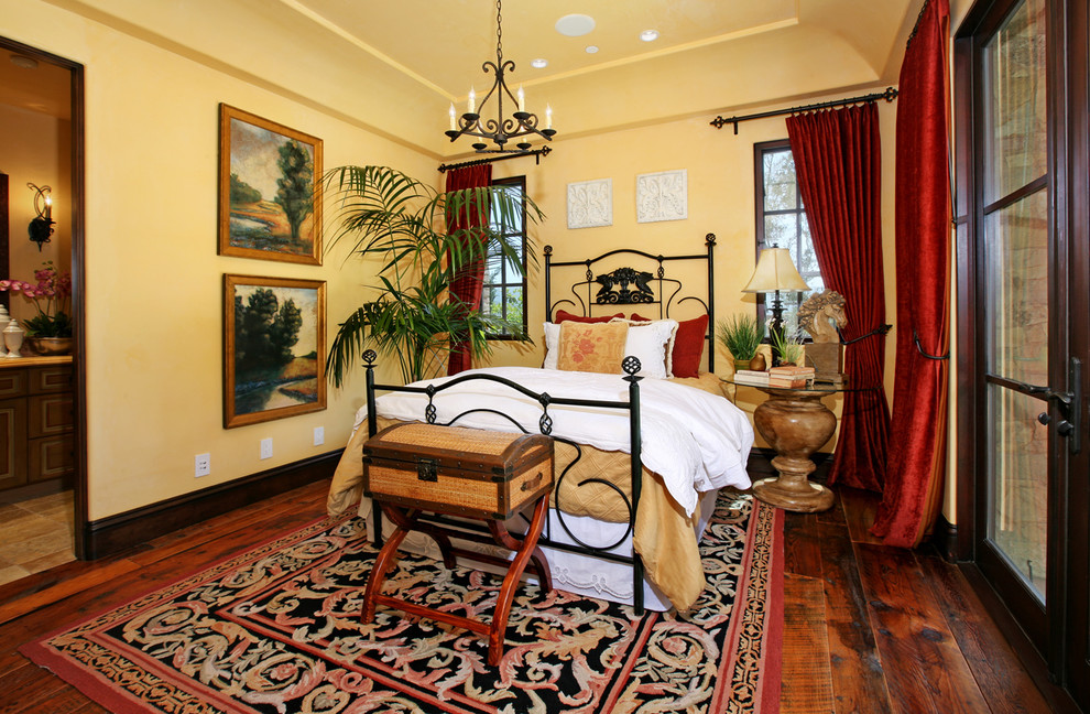 Mittelgroßes Mediterranes Gästezimmer ohne Kamin mit gelber Wandfarbe und braunem Holzboden in Orange County
