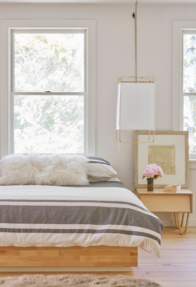 Skandinavisches Schlafzimmer mit weißer Wandfarbe und hellem Holzboden in New York