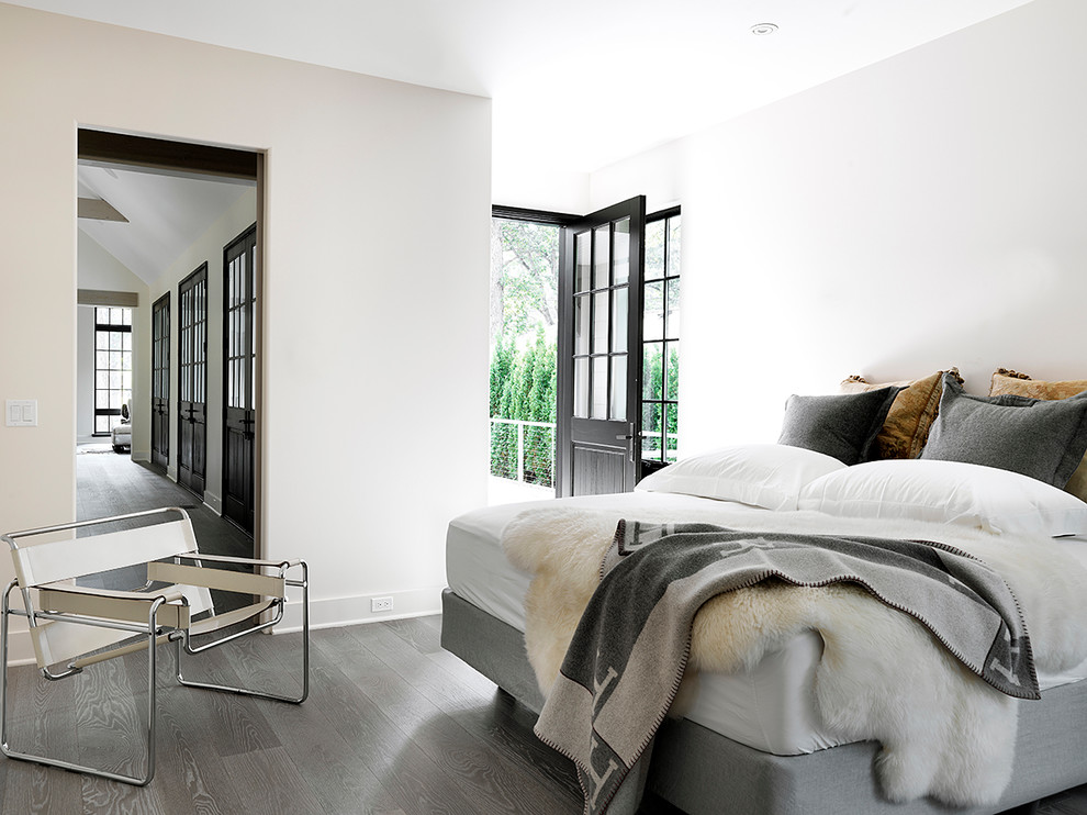 Immagine di una camera da letto nordica con pareti bianche, pavimento in legno massello medio e pavimento grigio