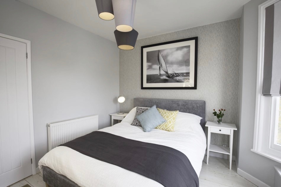 На фото: хозяйская спальня среднего размера в скандинавском стиле с серыми стенами, светлым паркетным полом и белым полом