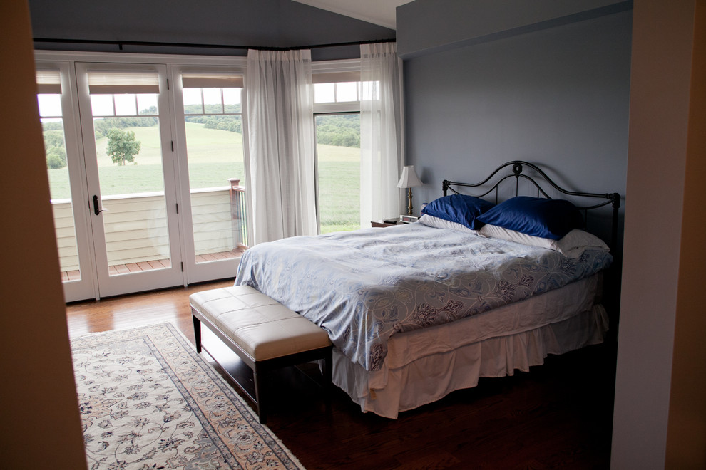 Modelo de habitación de invitados contemporánea grande sin chimenea con paredes azules y suelo de madera en tonos medios
