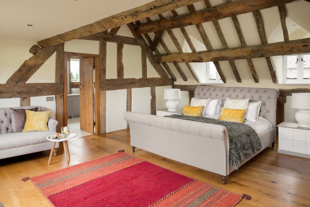 Imagen de dormitorio de estilo de casa de campo de tamaño medio con paredes beige, suelo de madera en tonos medios y suelo beige