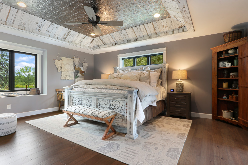 Immagine di una camera degli ospiti country con pareti grigie, pavimento in legno massello medio e pavimento marrone