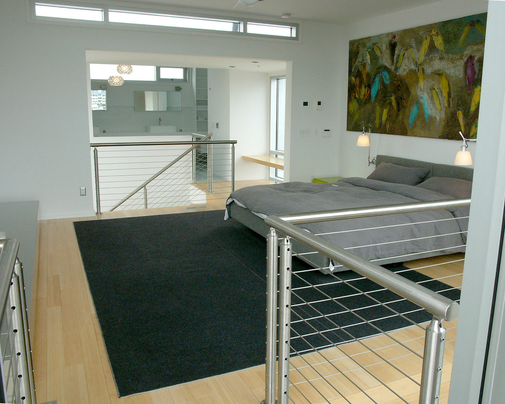 Immagine di una camera da letto stile loft contemporanea di medie dimensioni con pareti bianche, parquet chiaro, nessun camino e pavimento marrone