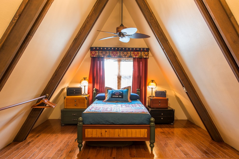 Modelo de dormitorio tipo loft tradicional de tamaño medio con paredes beige y suelo de madera oscura