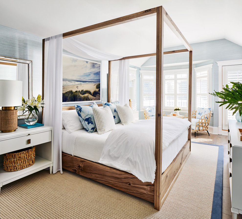 Diseño de dormitorio principal y abovedado costero grande con papel pintado, paredes azules, suelo de madera en tonos medios y suelo marrón