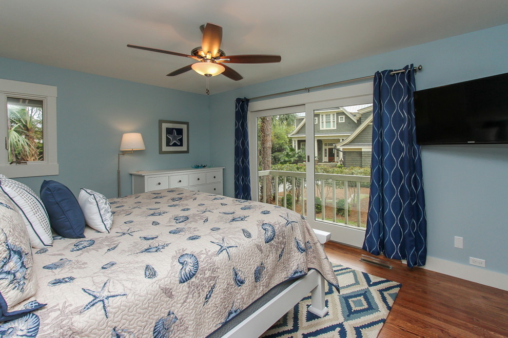 Aménagement d'une chambre d'amis bord de mer de taille moyenne avec un mur bleu et un sol en bois brun.