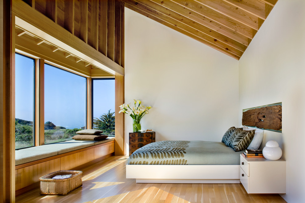 Imagen de dormitorio principal rural con paredes blancas y suelo de madera clara