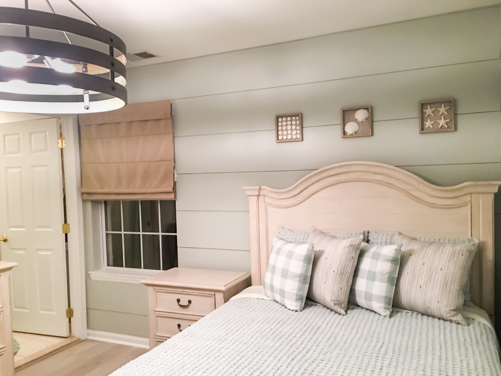Modelo de dormitorio costero de tamaño medio con paredes verdes, suelo vinílico y suelo beige