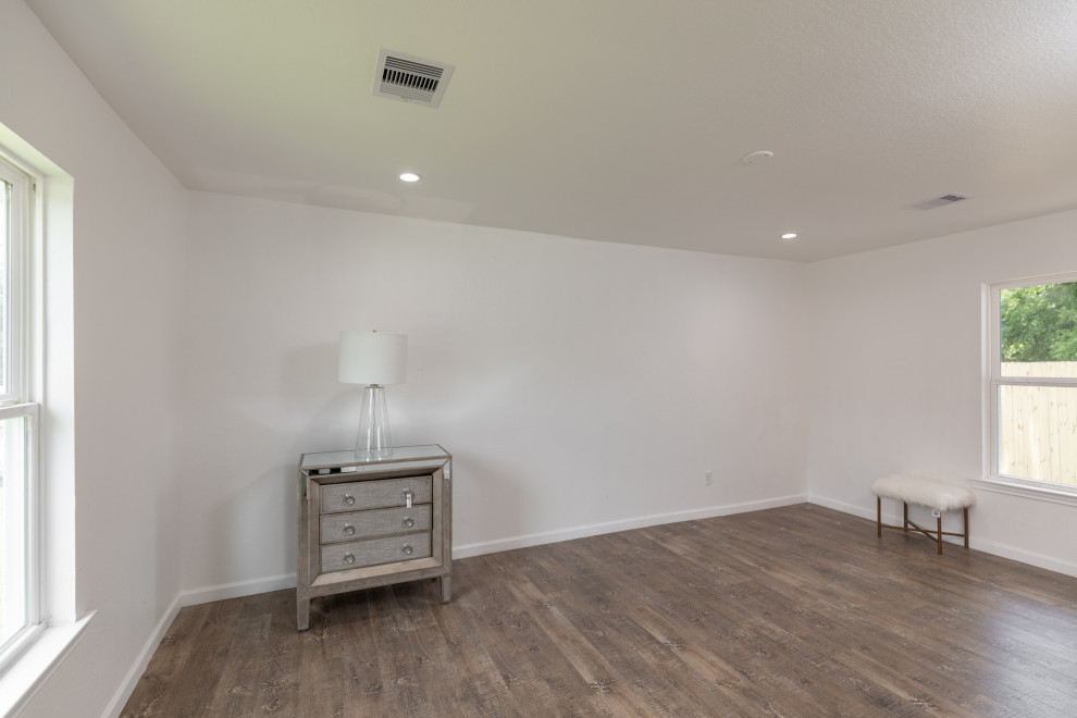ヒューストンにある中くらいなカントリー風のおしゃれな主寝室 (白い壁、ラミネートの床、茶色い床) のレイアウト