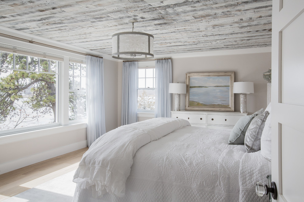 Photo of a coastal bedroom in Boston with light hardwood flooring, beige floors and grey walls.