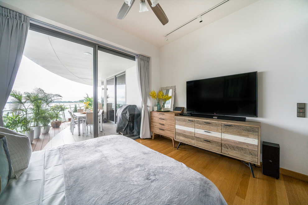 Modelo de habitación de invitados costera con paredes blancas, suelo de madera en tonos medios y suelo beige