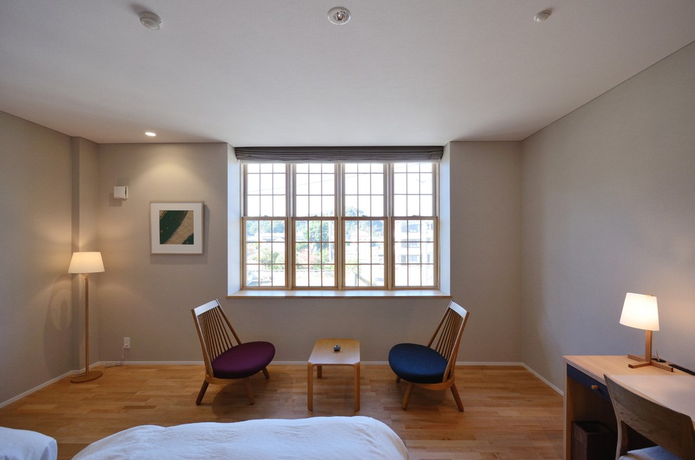 Idée de décoration pour une chambre d'amis minimaliste de taille moyenne avec un mur beige, parquet clair et un sol beige.