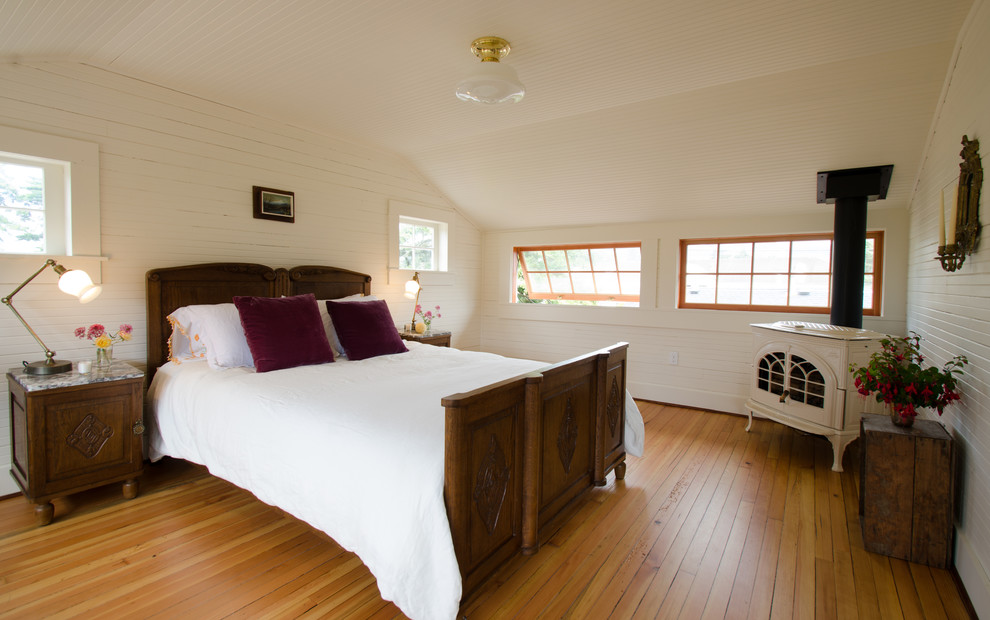 Inspiration for a beach style bedroom in Portland with beige walls and medium hardwood flooring.