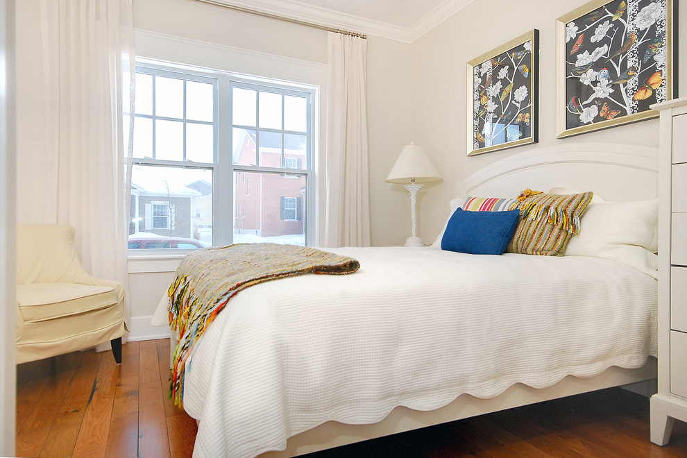 Modelo de dormitorio principal costero de tamaño medio sin chimenea con paredes beige, suelo de madera en tonos medios y suelo marrón