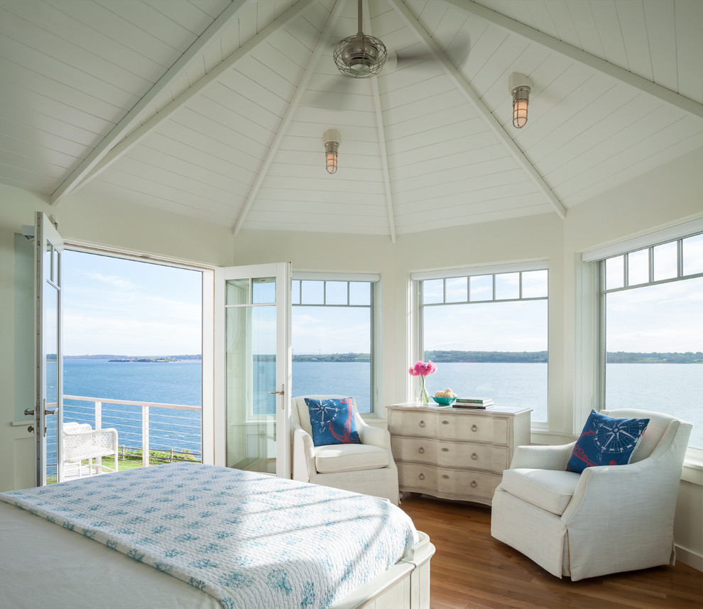 На фото: хозяйская спальня в морском стиле с белыми стенами и паркетным полом среднего тона с