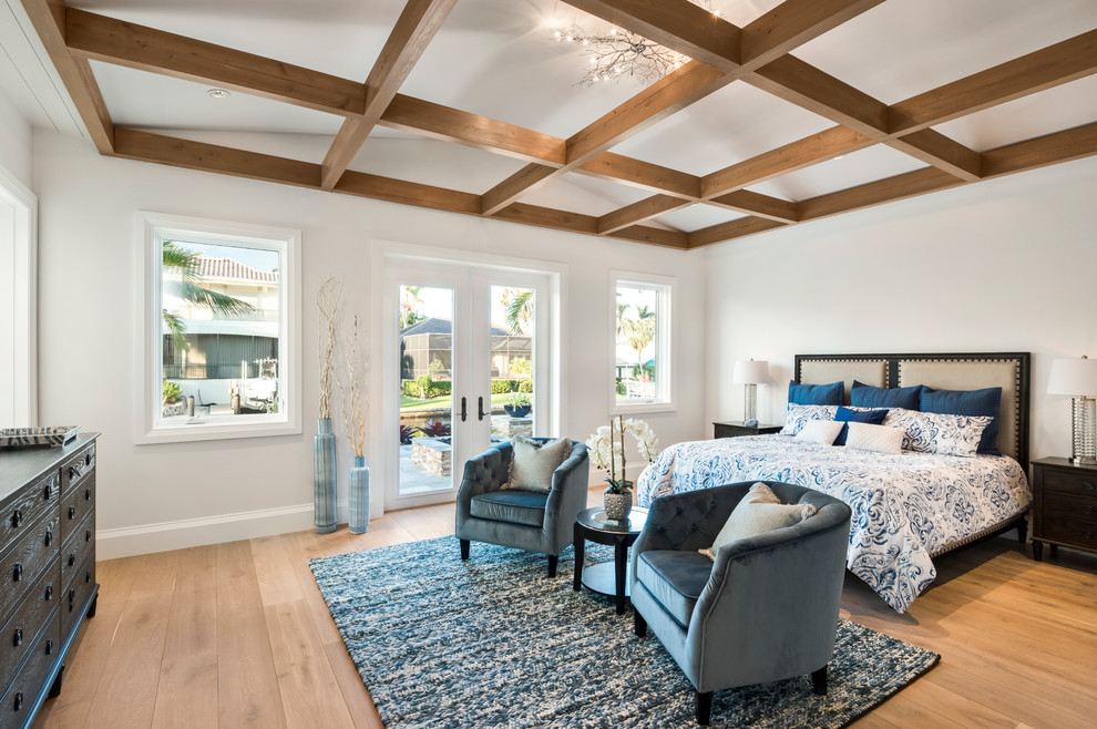 This is an example of a large nautical master bedroom in Other with white walls, medium hardwood flooring and brown floors.