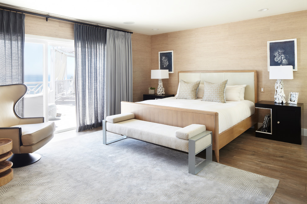 Immagine di una camera da letto stile marino con pareti beige e pavimento in legno massello medio