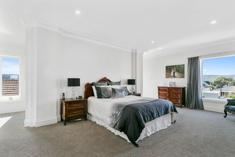 Example of a huge classic master carpeted and gray floor bedroom design in Wellington with white walls
